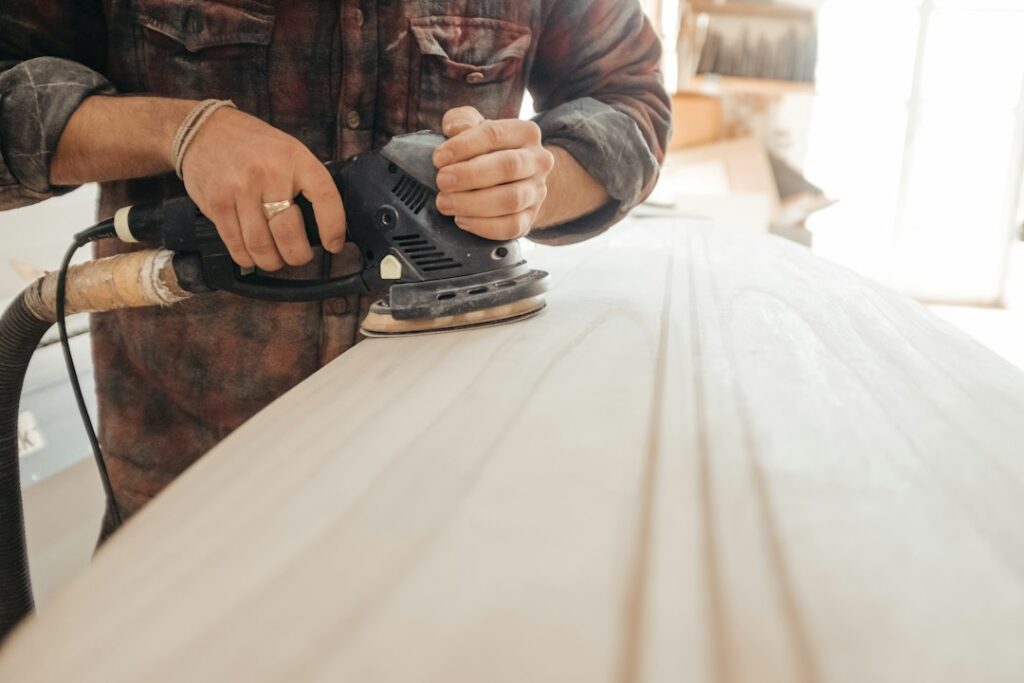 Profesional lijando madera en un taller, una aplicación que requiere control y extracción de polvo